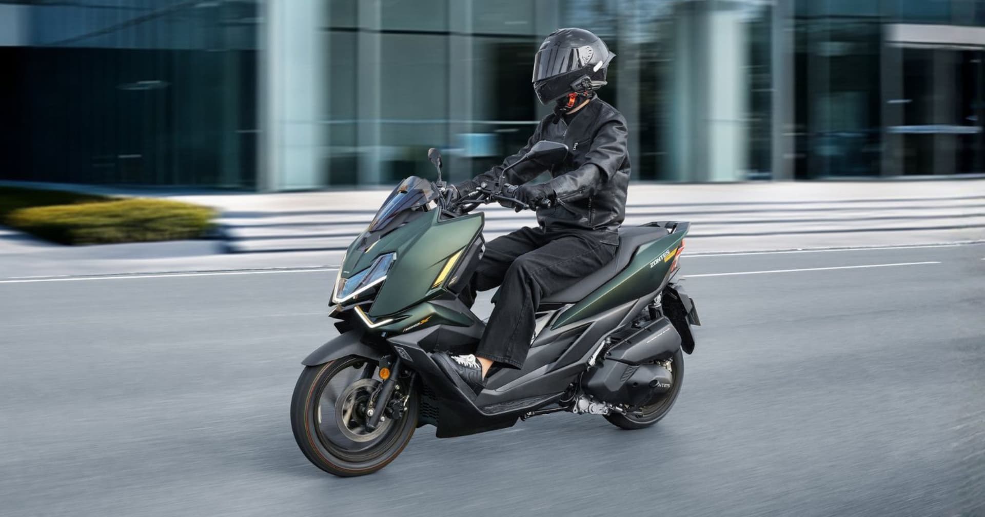 Scooter Zontes 125X verde conducido por una persona con casco en la ciudad.