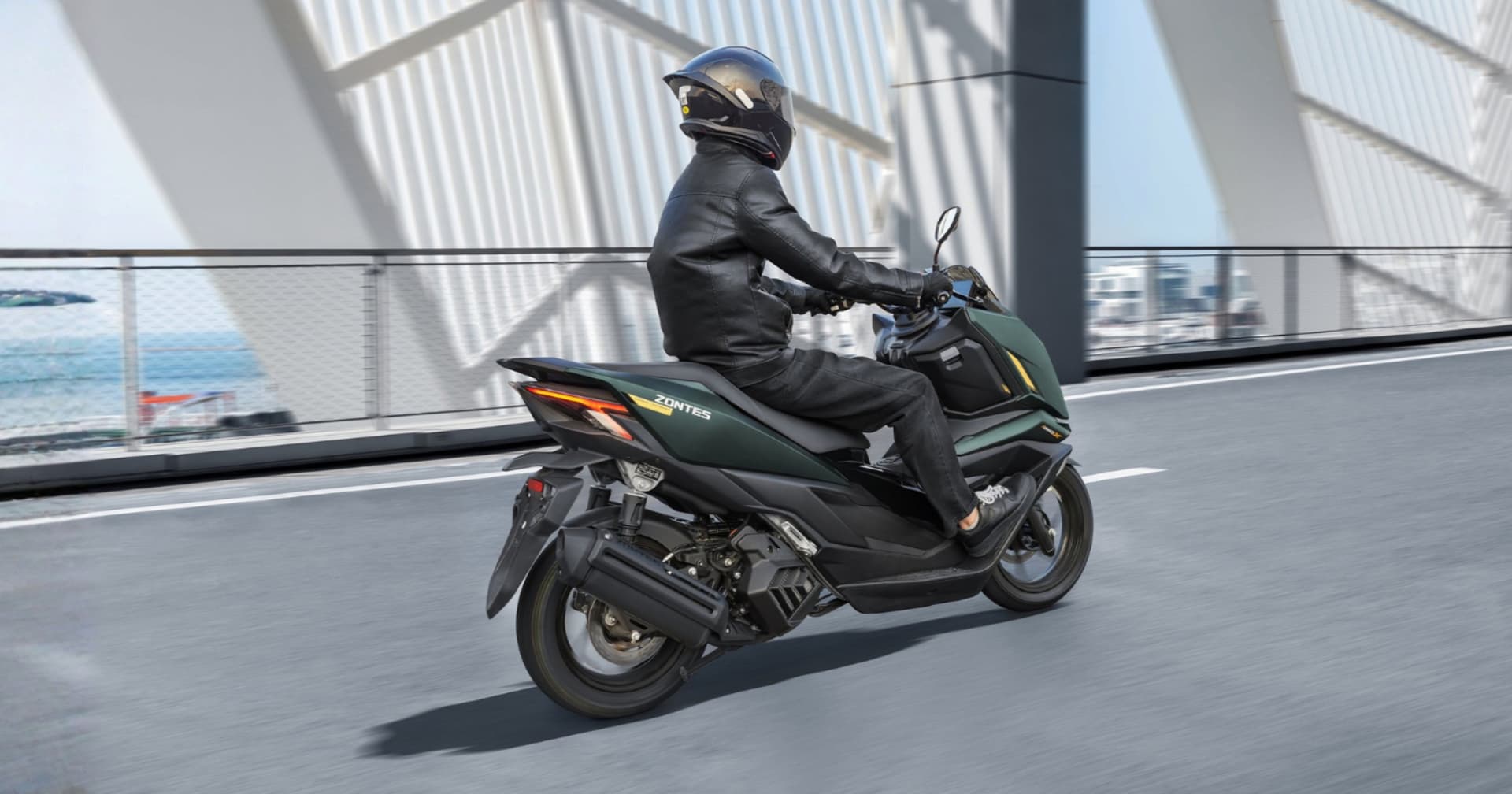 Scooter Zontes 125X verde oscuro con conductor en carretera moderna