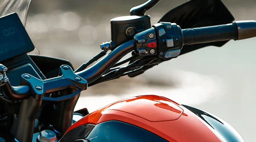 Detalle del manillar de una moto Zontes 350T en color naranja y negro.