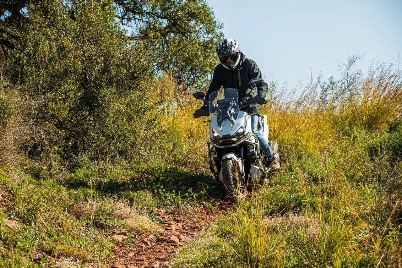 Moto Zontes 368G ADV blanca con piloto en camino rural
